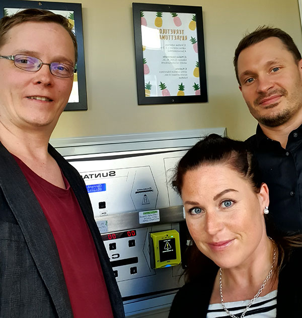 Installation completed. Customer Kirsi posing with suppliers Antti and Sami with Nayax Cashless Payment System.